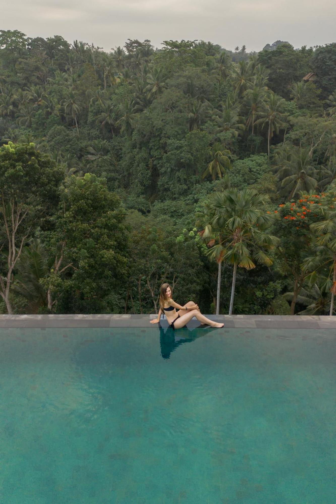 Goya Boutique Resort Ubud Esterno foto A woman sitting on the edge of a swimming pool